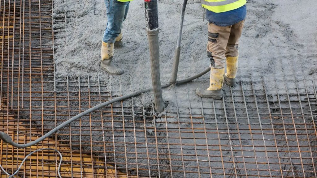 Workers with concrete pump tube for concrete installation_Victoria Concrete and Paving